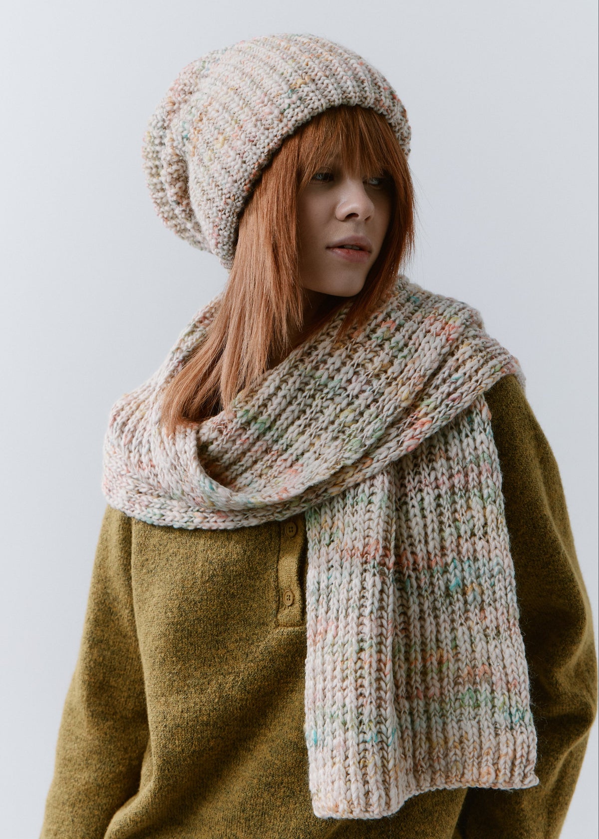 London Snowdrop knit beanie: Three-quarter portrait with matching scarf wrapped at the neck, sold separately
