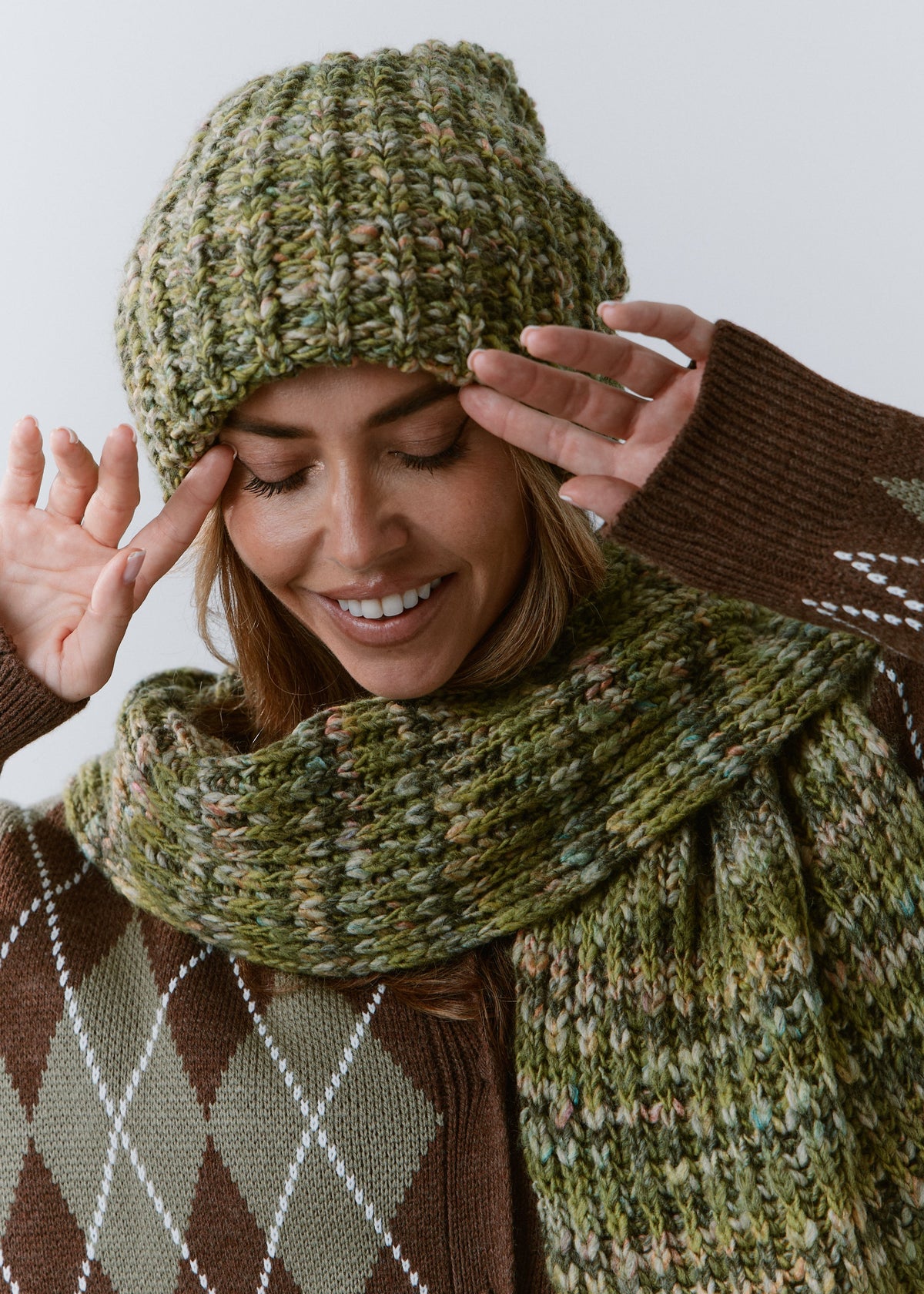 BRIKOLY Apple green multicolor ribbed knit scarf shown close up around a model's neck over an argyle sweater.