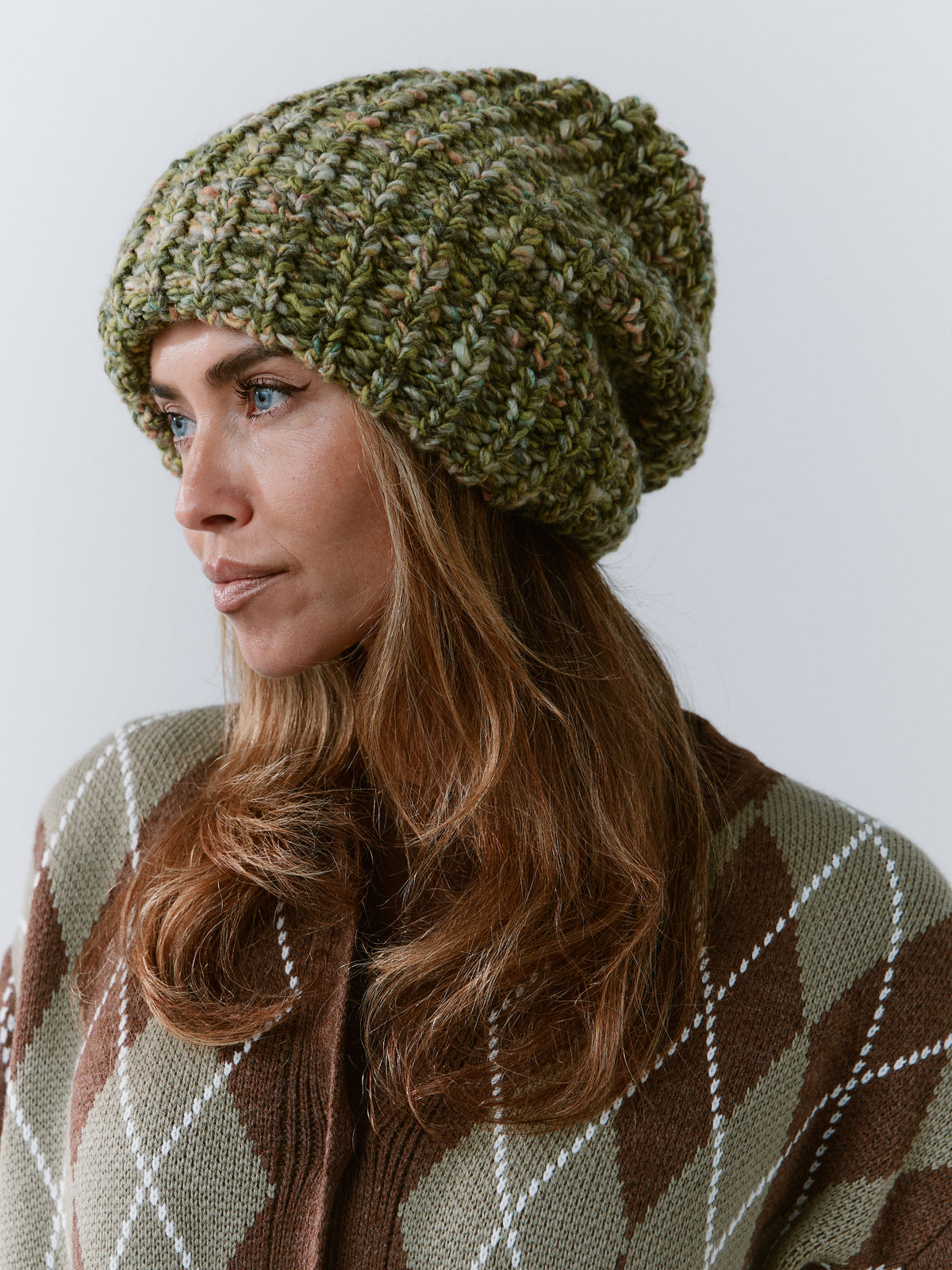 BRIKOLY Apple green oversized knit beanie shown in profile over an argyle sweater.