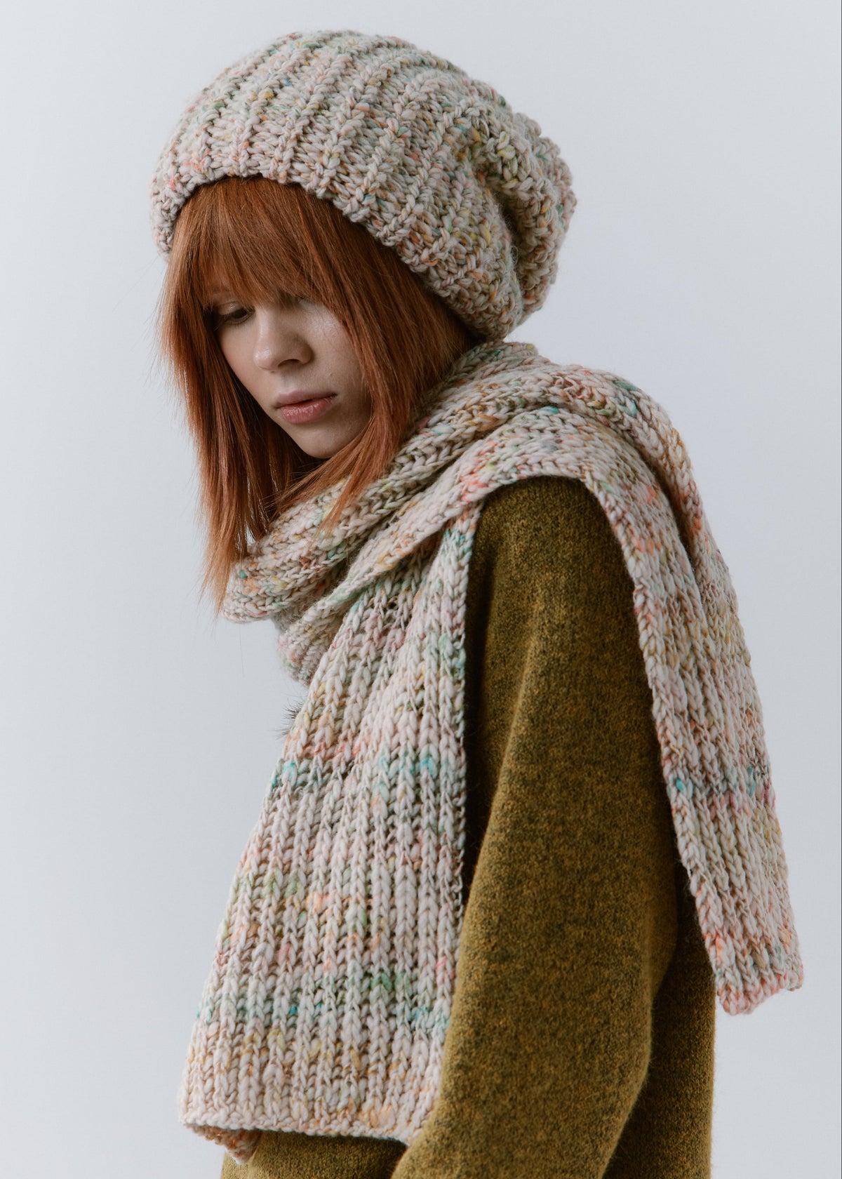 BRIKOLY Snowdrop pale multicolor oversized knit beanie worn by a model with a matching scarf draped over her shoulders.