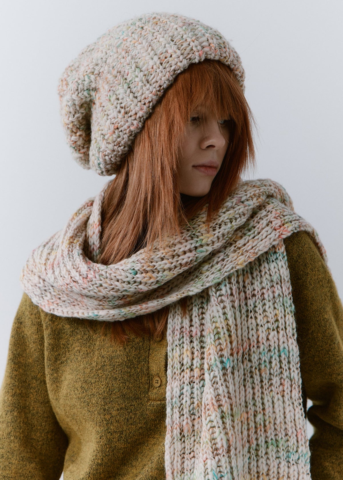 BRIKOLY Snowdrop pale multicolor oversized knit beanie worn by a model with a matching scarf wrapped around her neck.