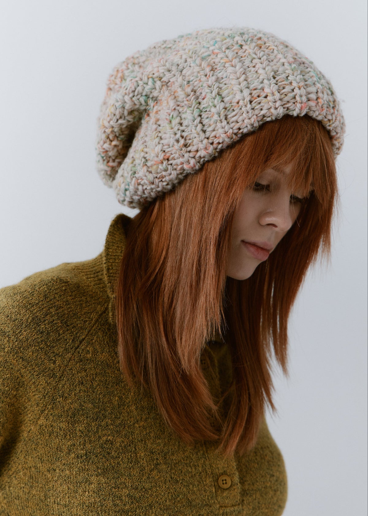 BRIKOLY Snowdrop pale multicolor oversized knit beanie worn by a model looking down, showing its relaxed slouchy shape.