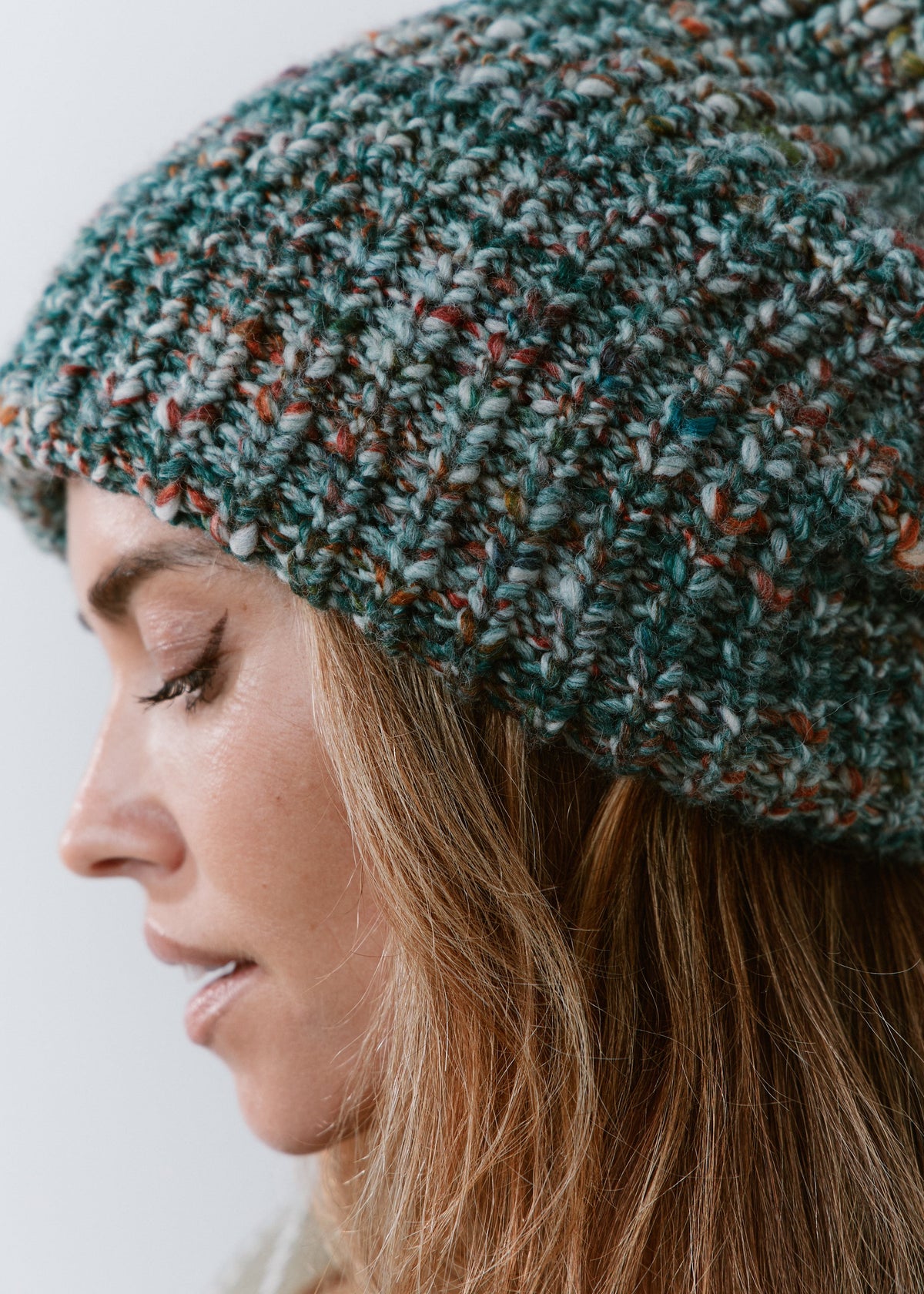 London Green and Orange knit beanie: Side close-up of the mixed green yarn