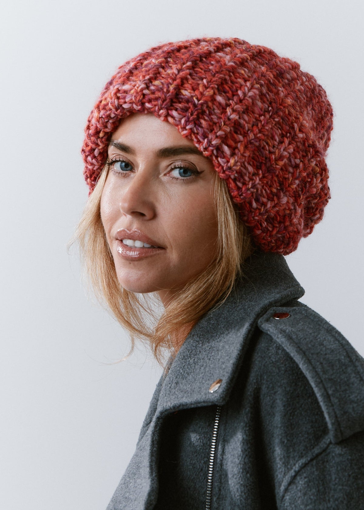 BRIKOLY Red oversized multicolor knit beanie worn by a model in a close three-quarter view.