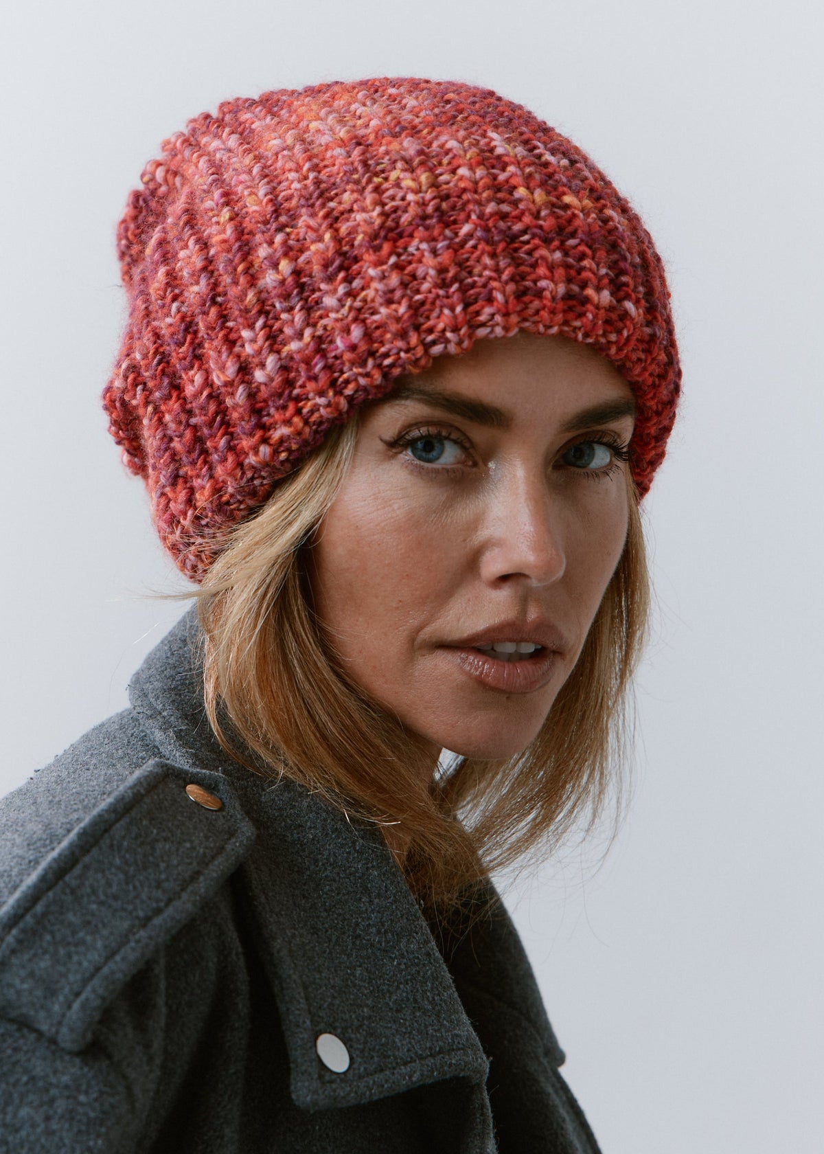 London Red knit beanie: Three-quarter close-up in a gray coat