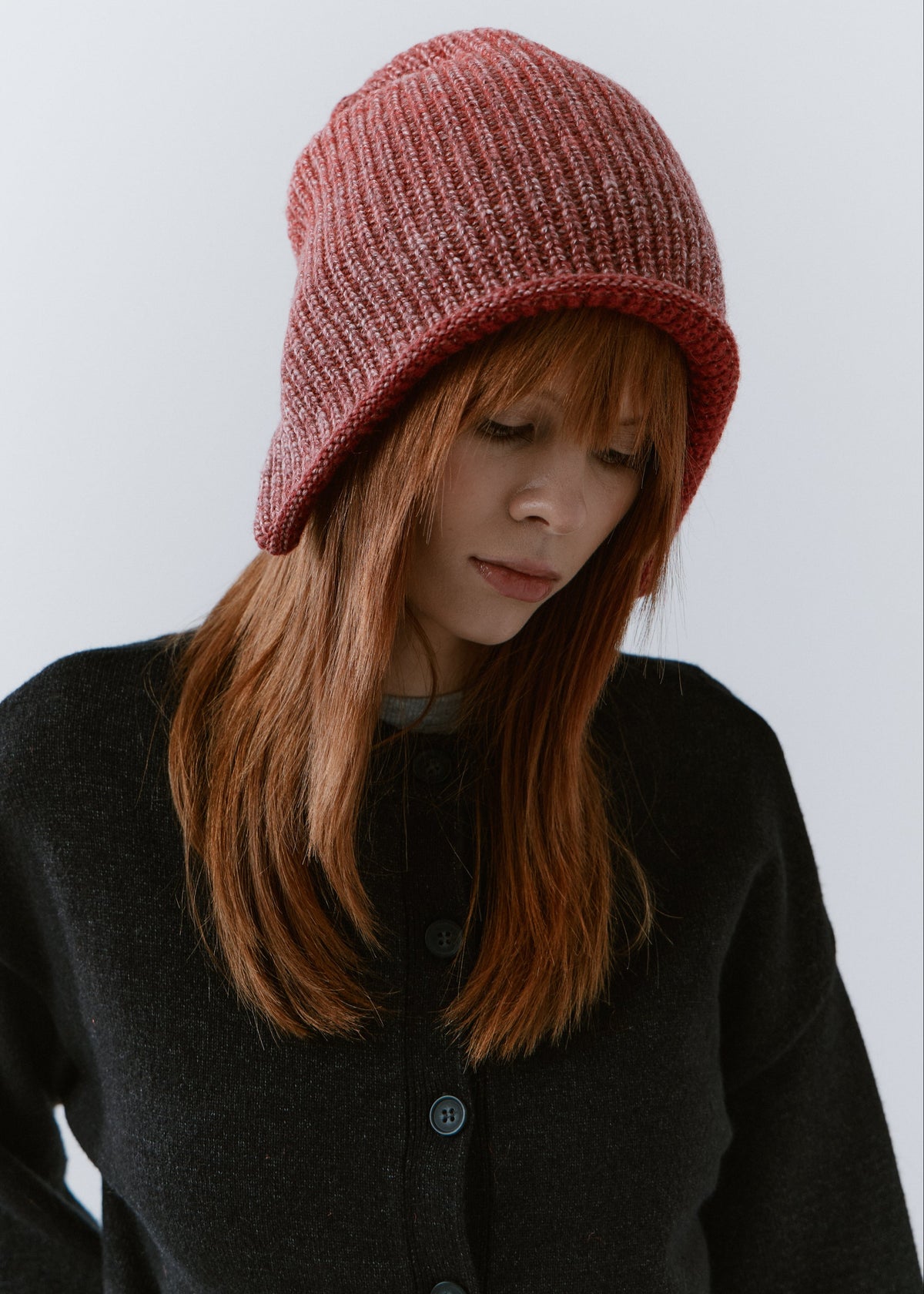 BRIKOLY Lisse Cherry reversible ribbed knit beanie worn by a model looking down.