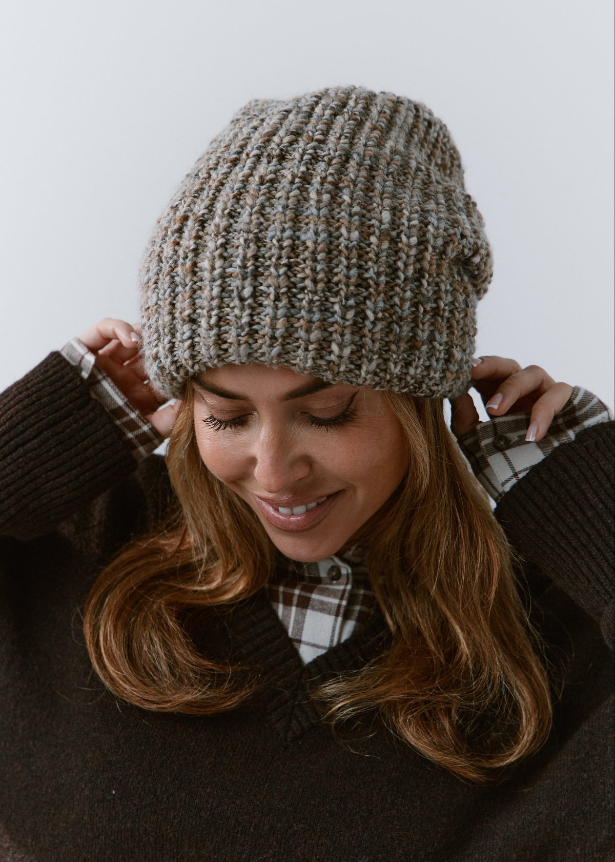London Gray knit beanie: Smiling portrait with hands at the brim