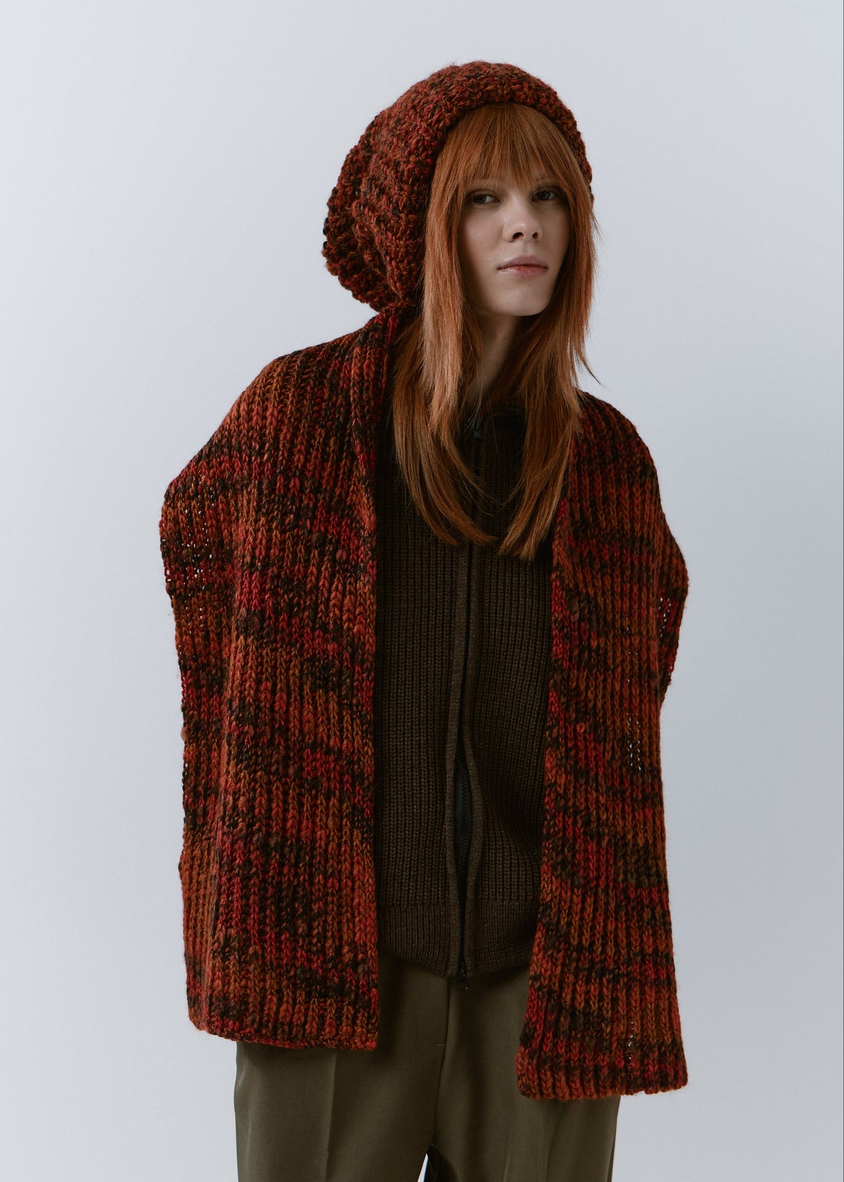 BRIKOLY Brown ribbed knit scarf in red-brown multicolor yarn, draped over a model's shoulders with both ends hanging in front.