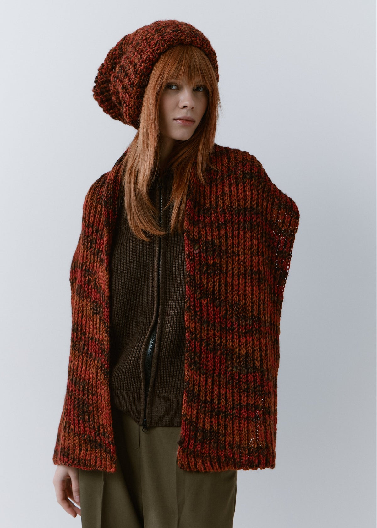 BRIKOLY Brown ribbed knit scarf in red-brown multicolor yarn, worn unwrapped with both ends hanging down the front.