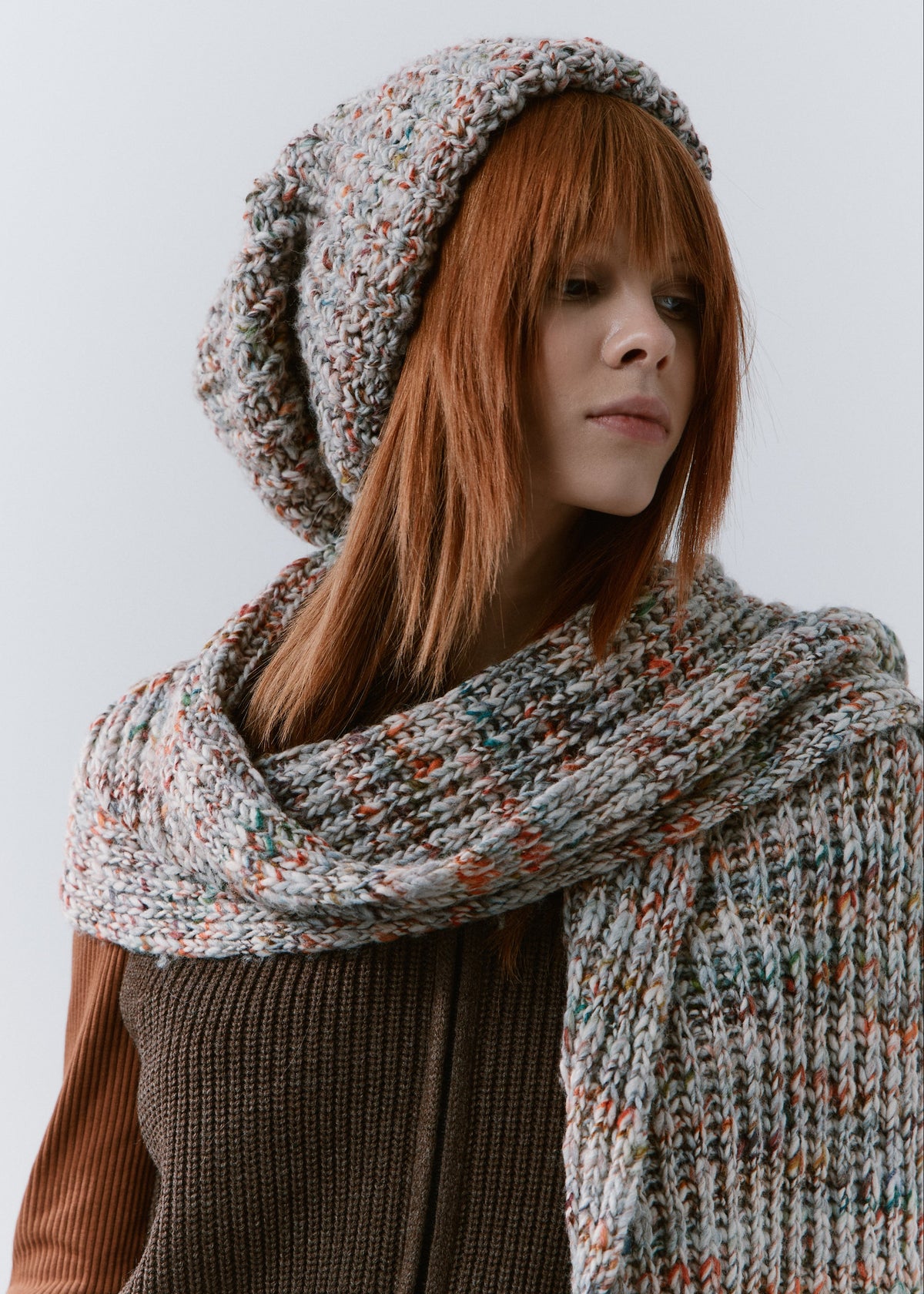 BRIKOLY FAN multicolor ribbed knit scarf wrapped loosely around the neck and styled with a matching slouchy beanie on a model.
