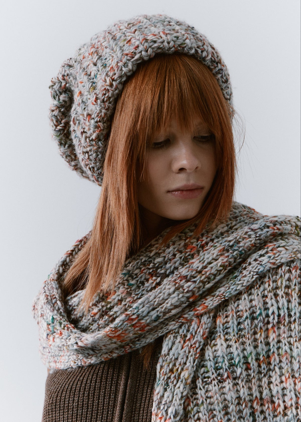 BRIKOLY FAN multicolor ribbed knit scarf draped across the shoulders, showing its chunky ribbed texture on a model.