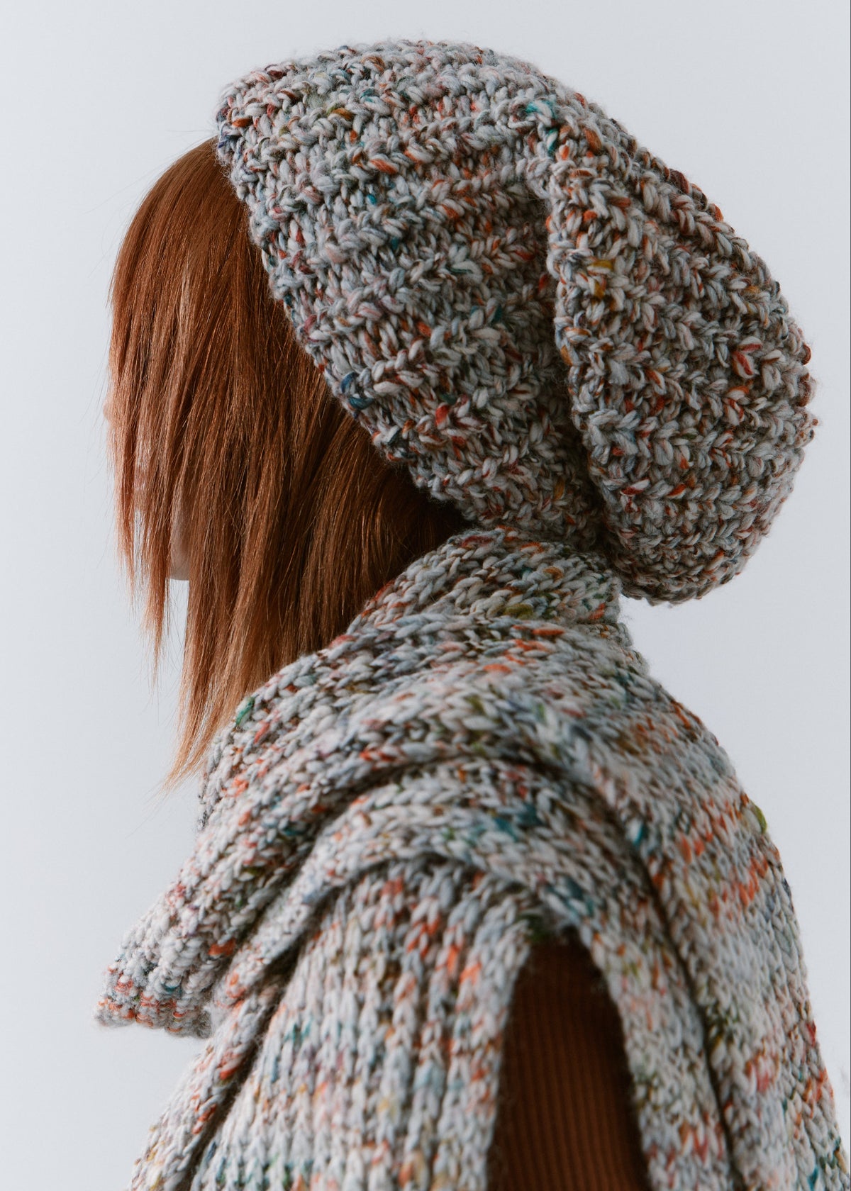 BRIKOLY FAN multicolor ribbed knit scarf draped across the upper back and shoulder in a rear side view on a model.