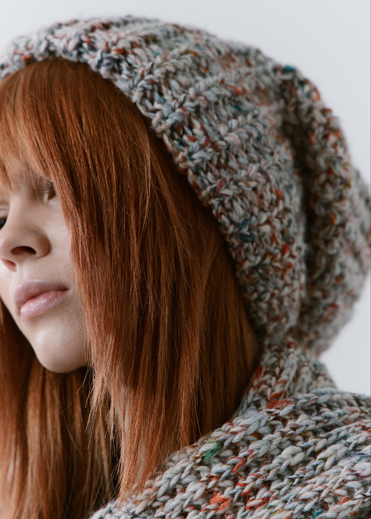 BRIKOLY FAN multicolor ribbed knit scarf shown close up around the neck beside a matching beanie on a model.