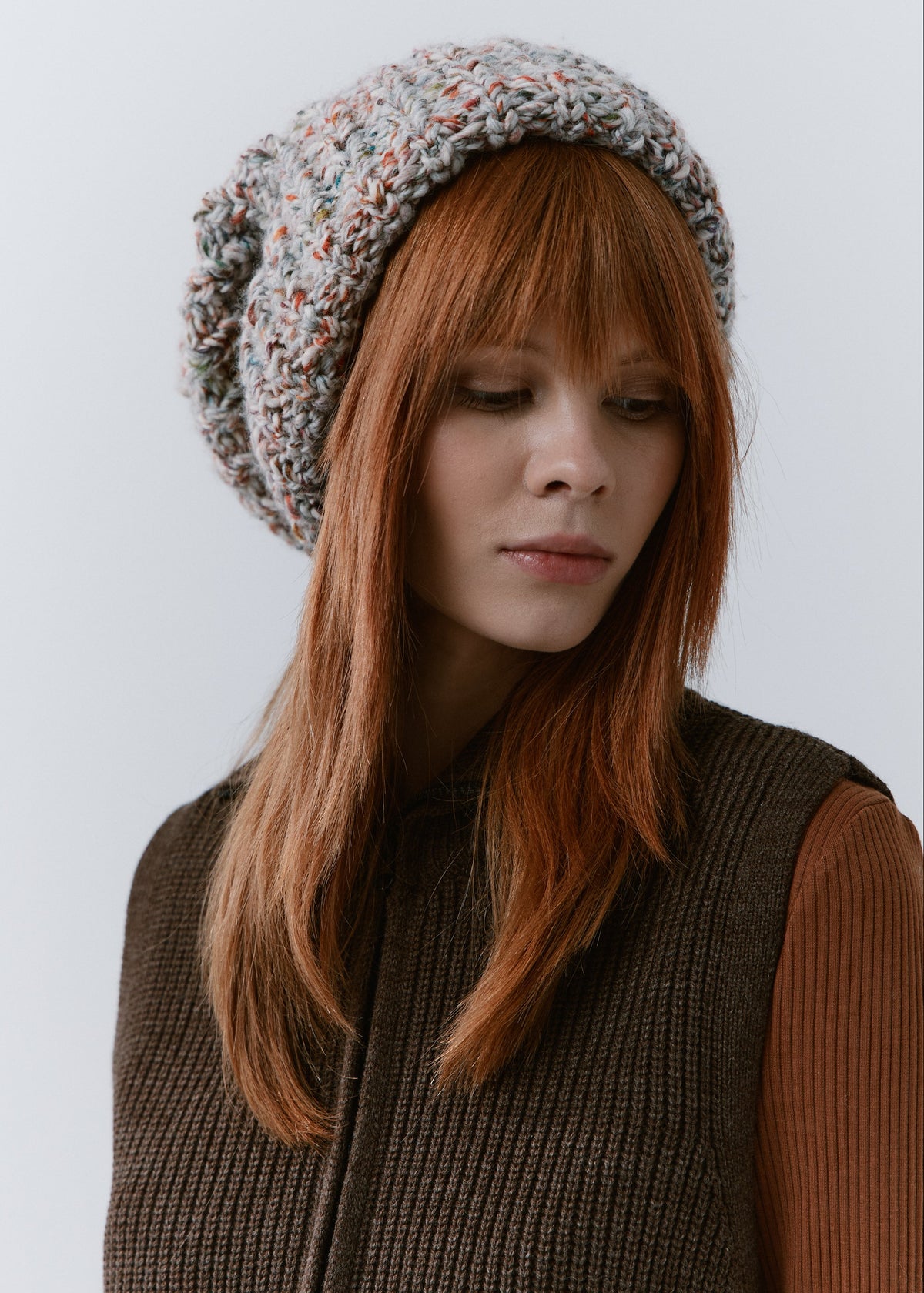BRIKOLY FAN oversized multicolor knit beanie worn by a model looking down.