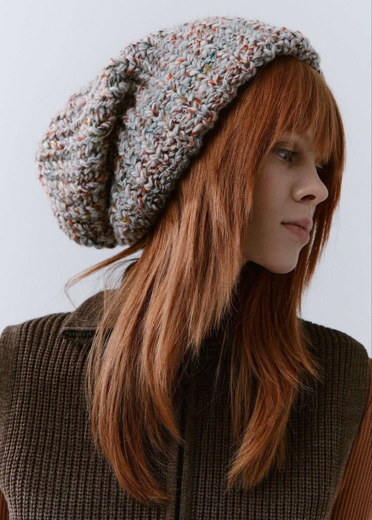 BRIKOLY FAN oversized multicolor knit beanie shown close up to reveal its pale multicolor knit and folded brim.