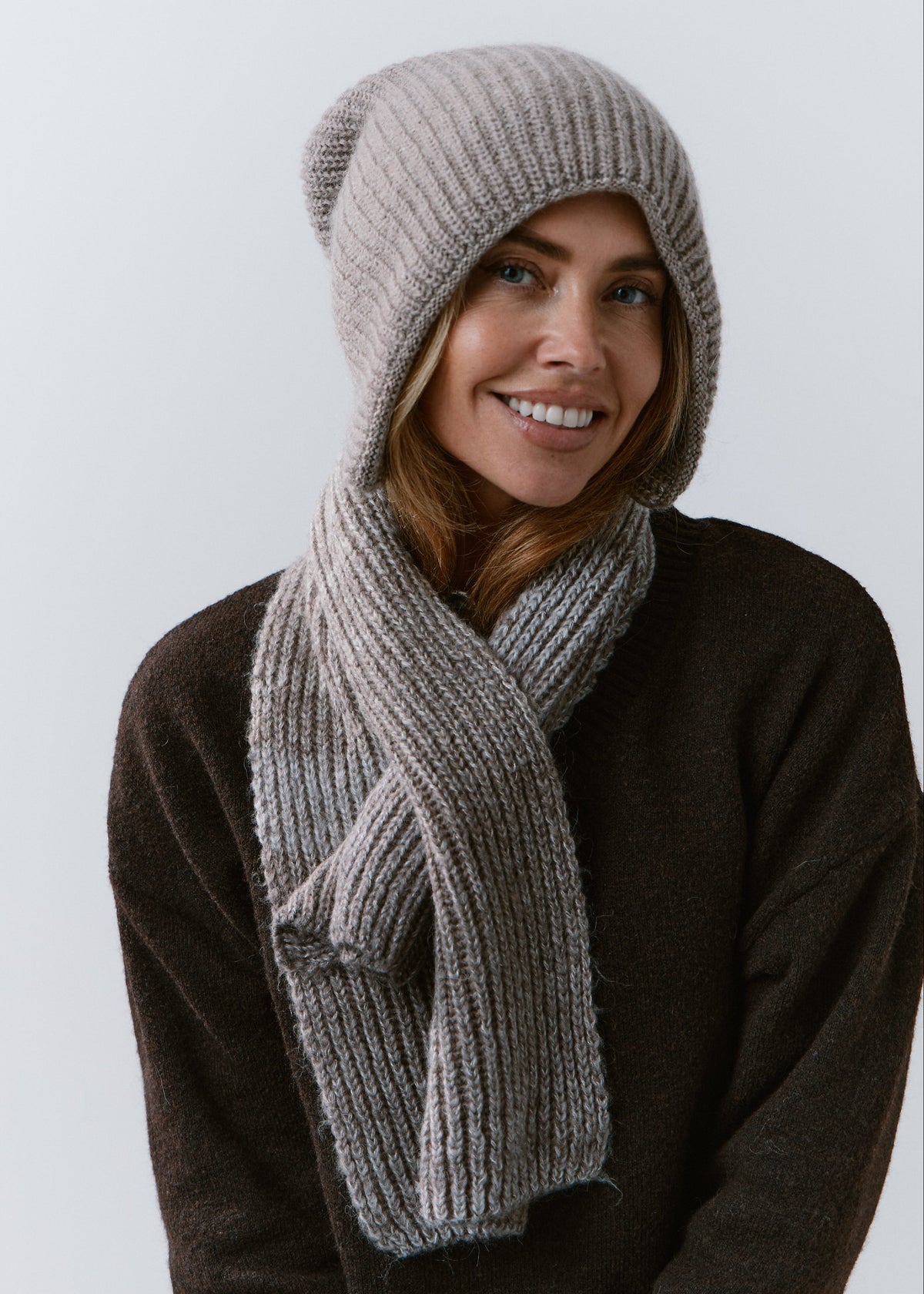 BRIKOLY Lisse Gray reversible ribbed knit beanie worn by a smiling model with a matching gray scarf.