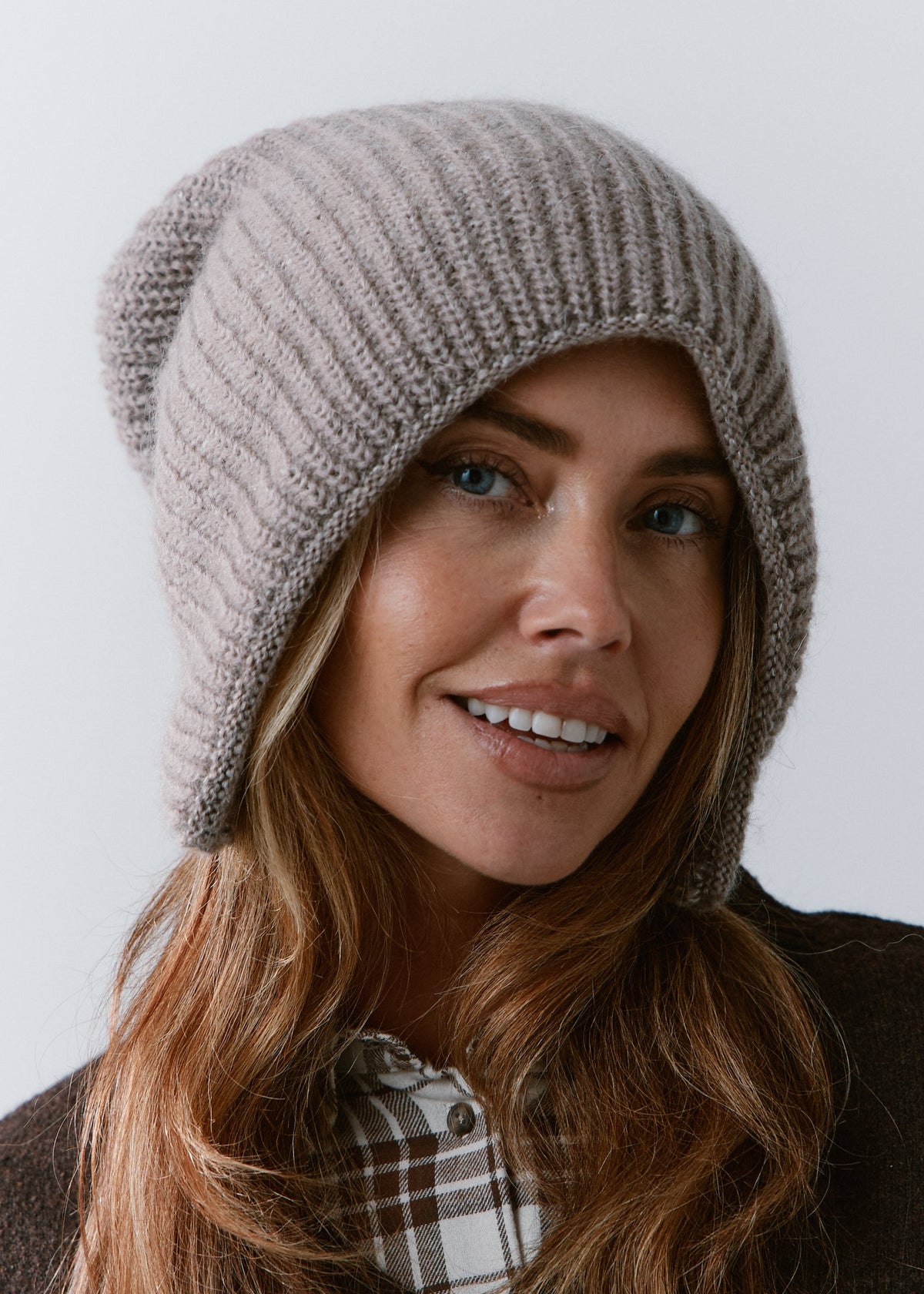 BRIKOLY Lisse Gray reversible ribbed knit beanie shown close up on a smiling model.