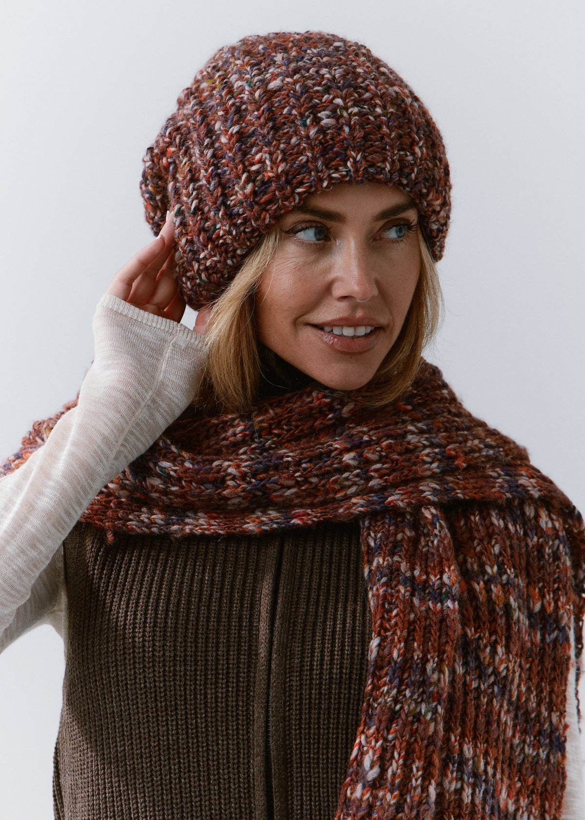 BRIKOLY Eggplant oversized multicolor knit beanie worn by a model adjusting the brim and looking to the side.