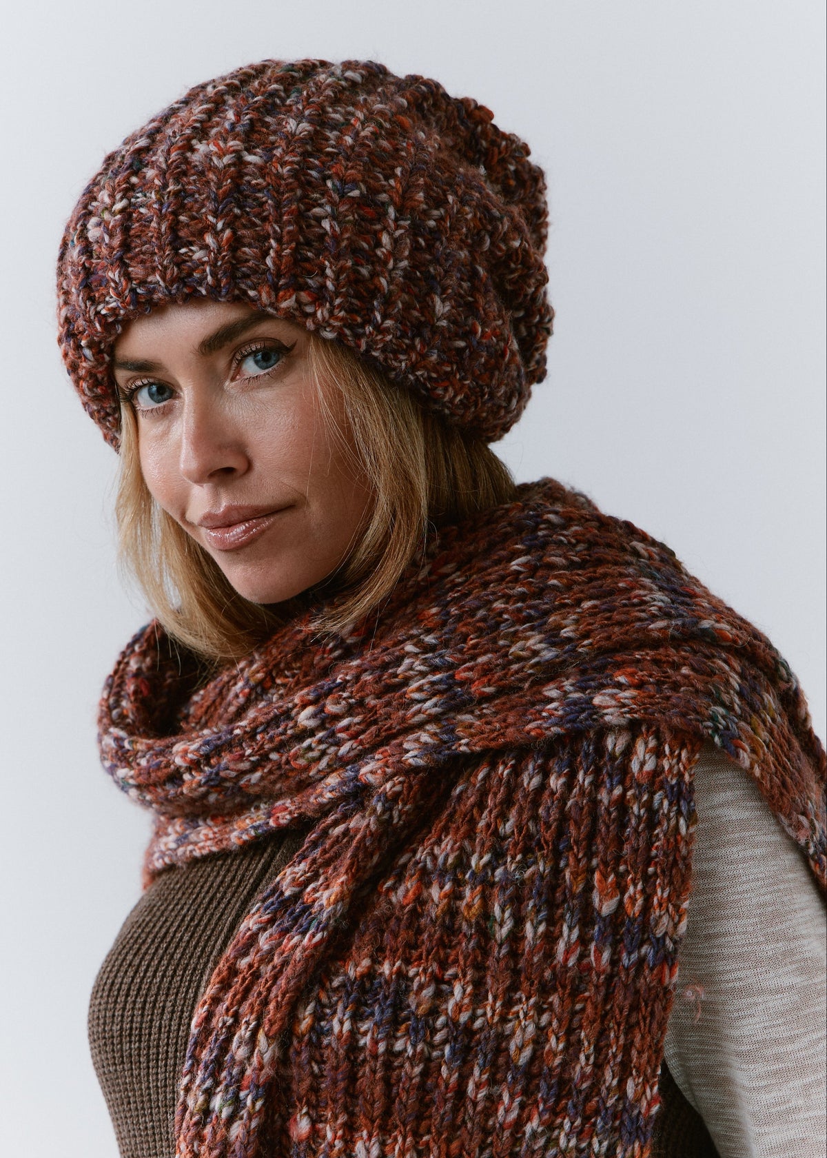 BRIKOLY Eggplant multicolor ribbed knit scarf wrapped across a model's shoulders in a three-quarter view.