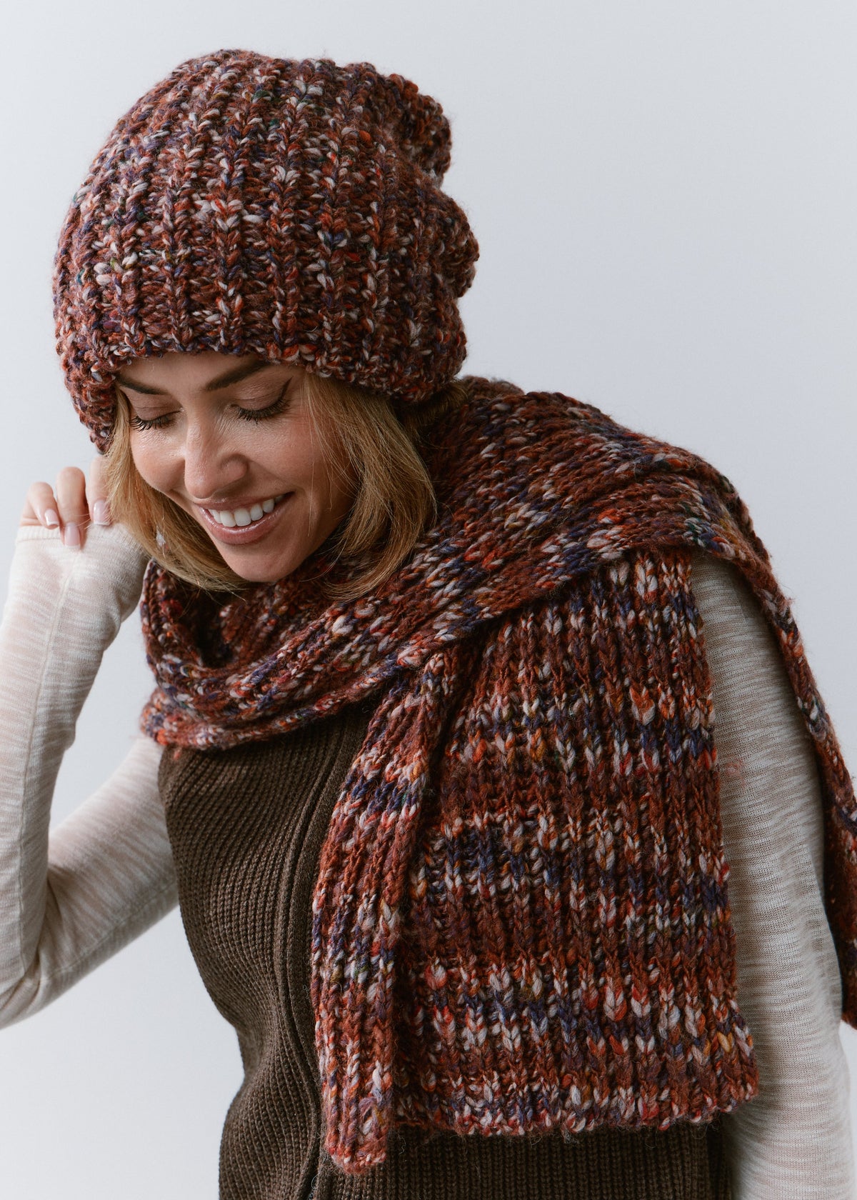 BRIKOLY Eggplant oversized multicolor knit beanie worn by a smiling model looking down.