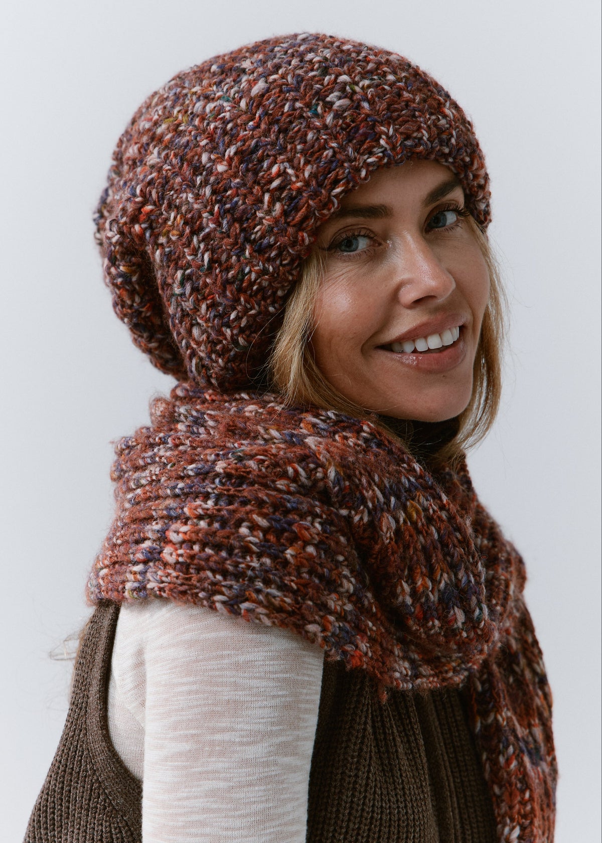 BRIKOLY Eggplant multicolor ribbed knit scarf wrapped across a model's upper back and shoulders in a rear three-quarter view.