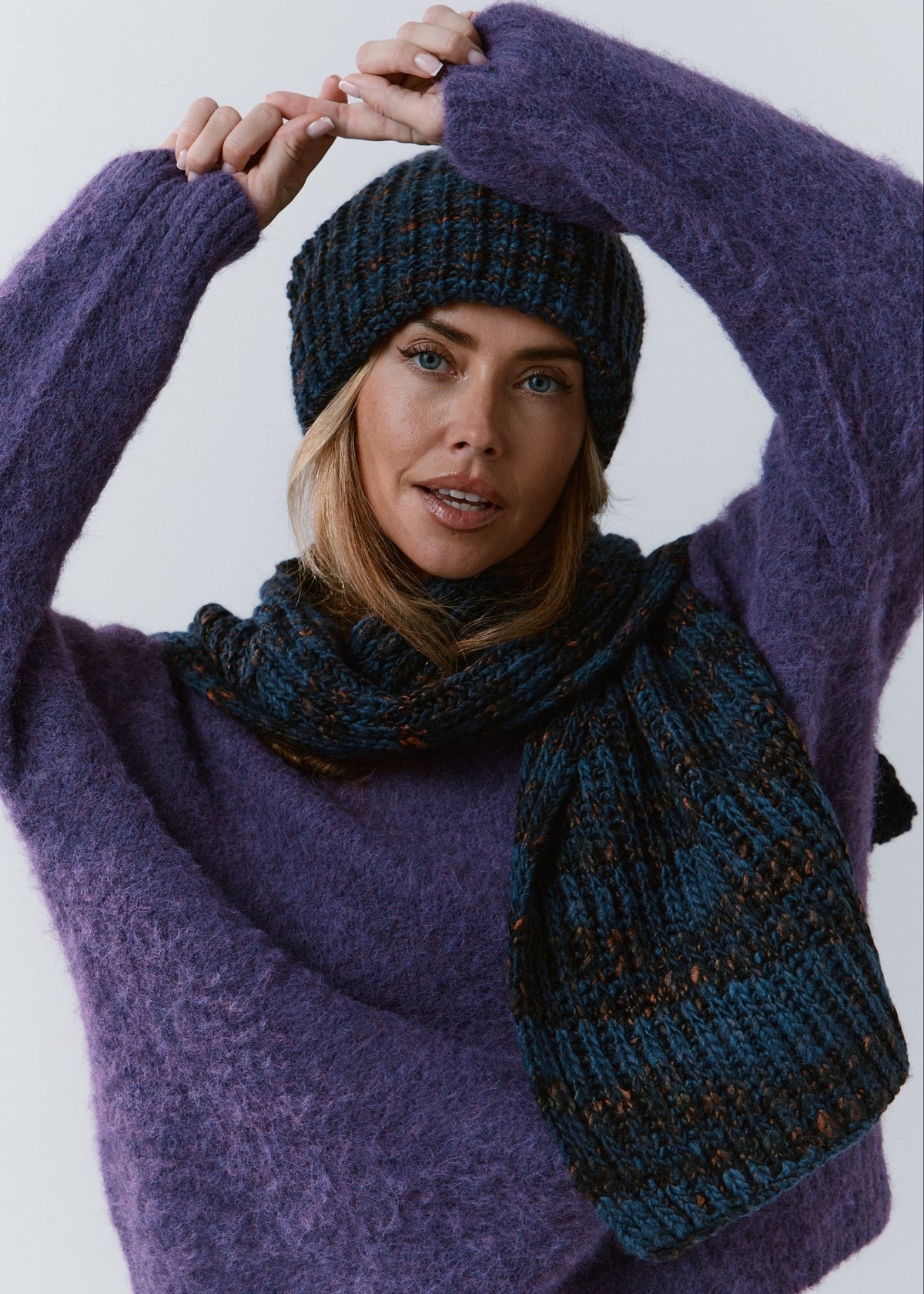 London Dark Lavender knit beanie: Front portrait with raised arms and matching scarf, sold separately