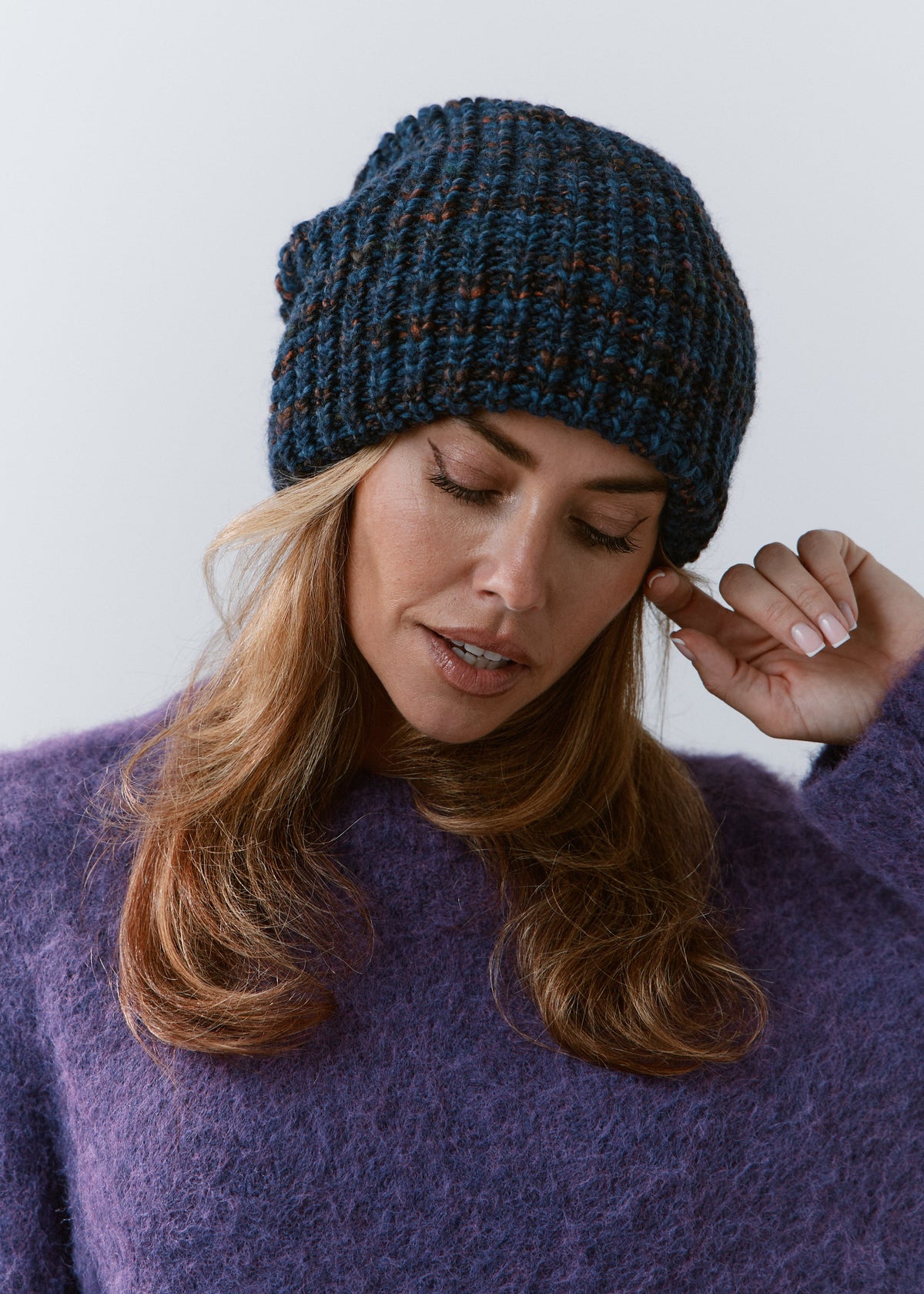 London Dark Lavender knit beanie: Front portrait with a hand beside the face