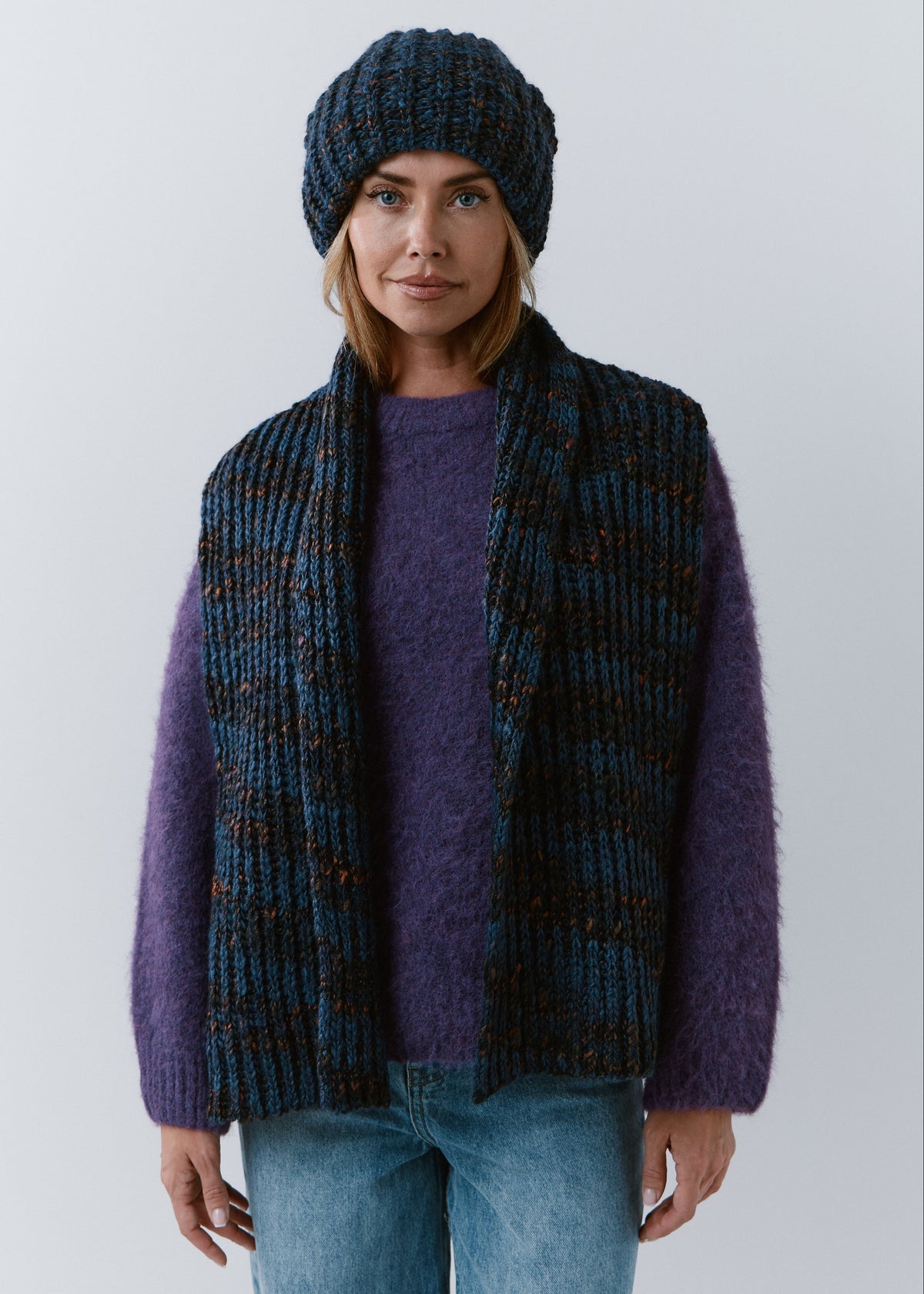 BRIKOLY Dark Lavender ribbed knit scarf in dark blue multicolor yarn, draped over a model's shoulders with both ends hanging in front.