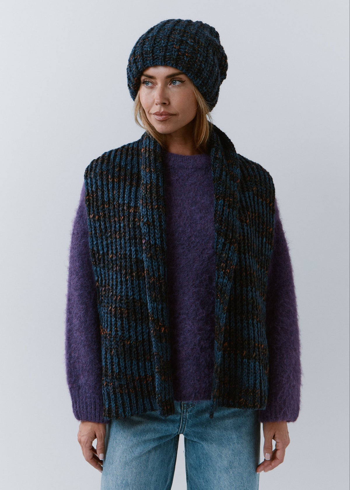 BRIKOLY Dark Lavender ribbed knit scarf in dark blue multicolor yarn, worn unwrapped with both ends hanging down the front.