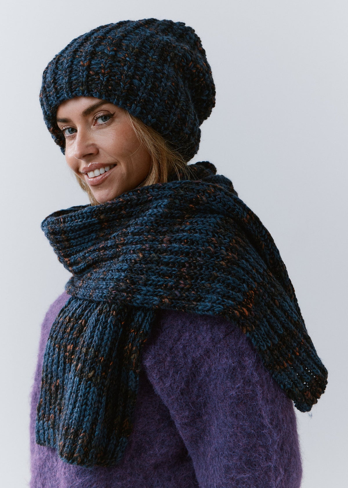 BRIKOLY Dark Lavender ribbed knit scarf in dark blue multicolor yarn, draped across a model's shoulders in a side view.