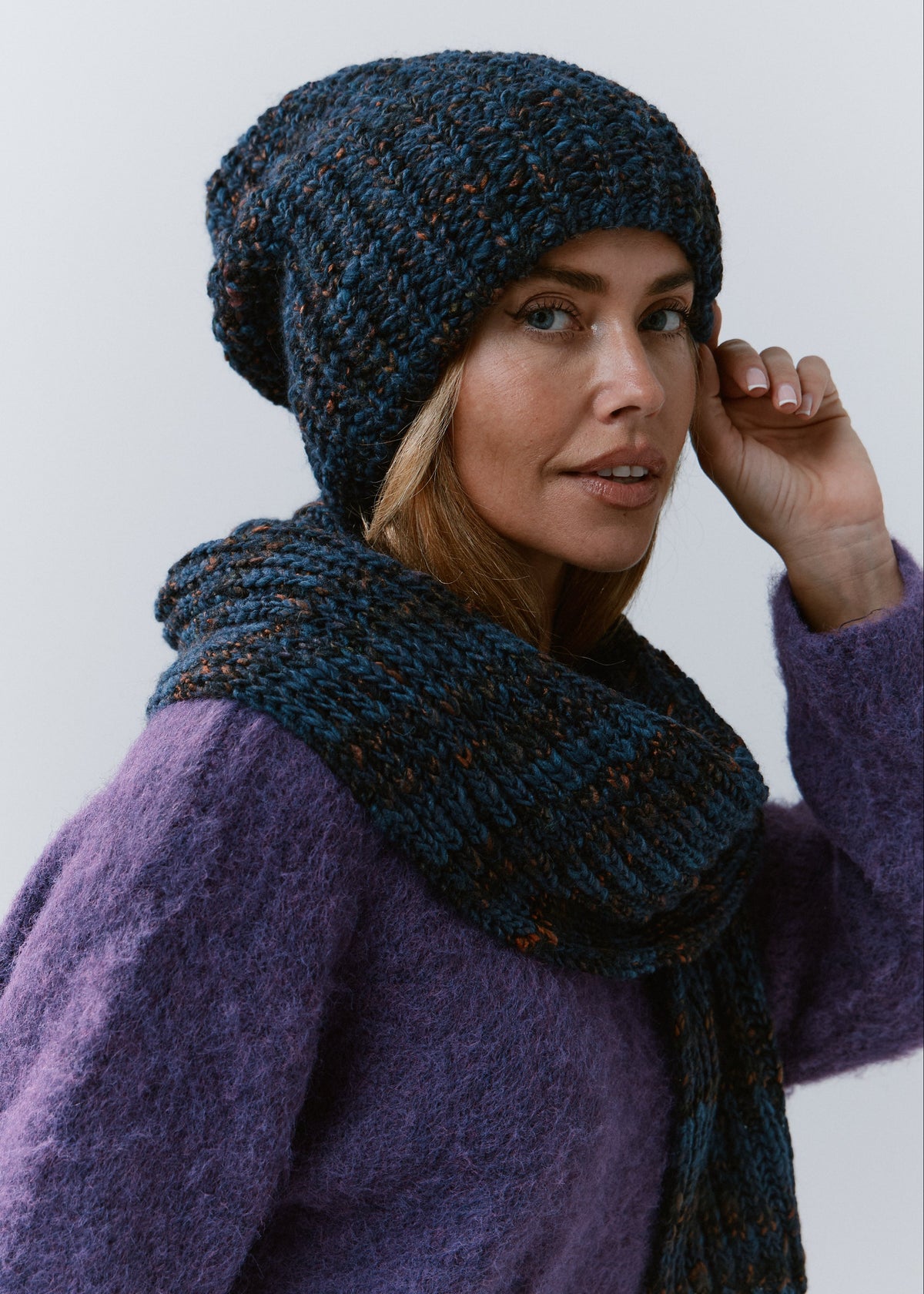 BRIKOLY Dark Lavender ribbed knit scarf in dark blue multicolor yarn, wrapped around a model's neck in a three-quarter view.