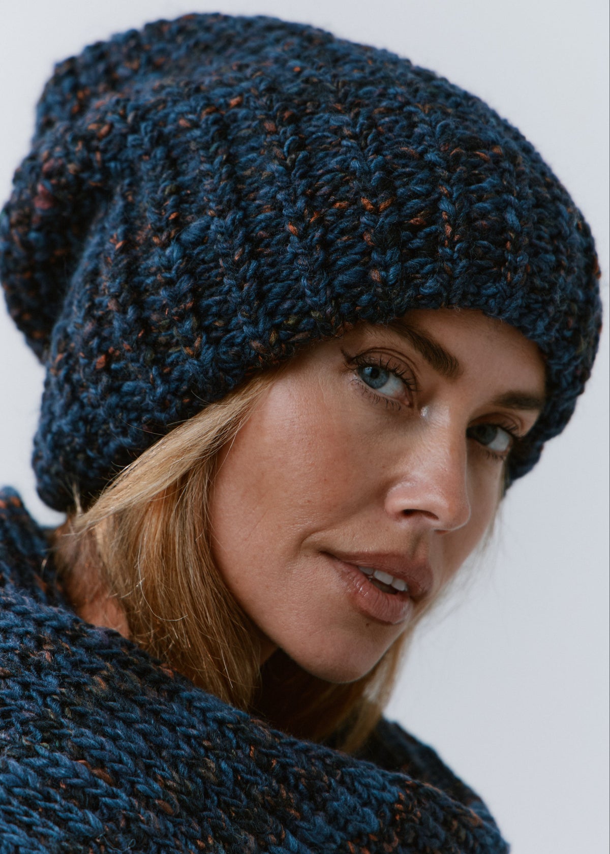 BRIKOLY Dark Lavender oversized knit beanie shown close up to reveal its dark blue multicolor yarn and ribbed brim.