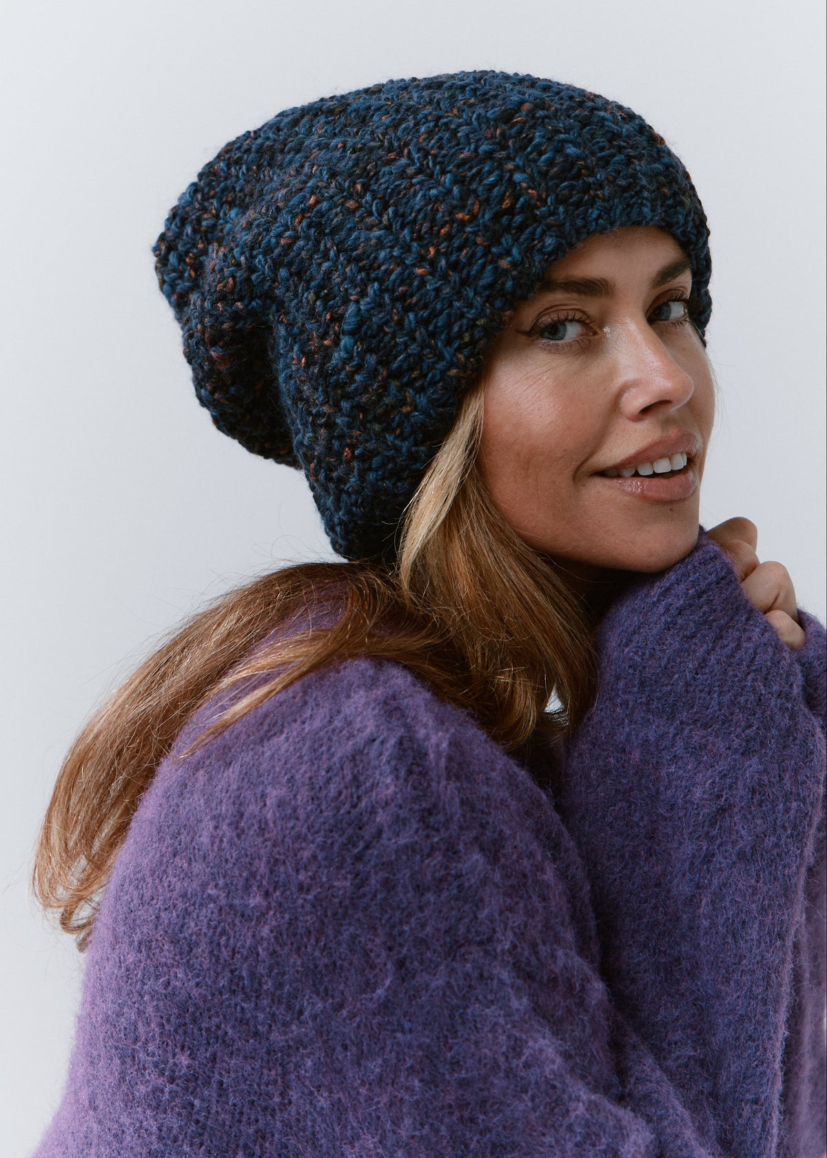 BRIKOLY Dark Lavender oversized knit beanie worn by a model looking back toward the camera.