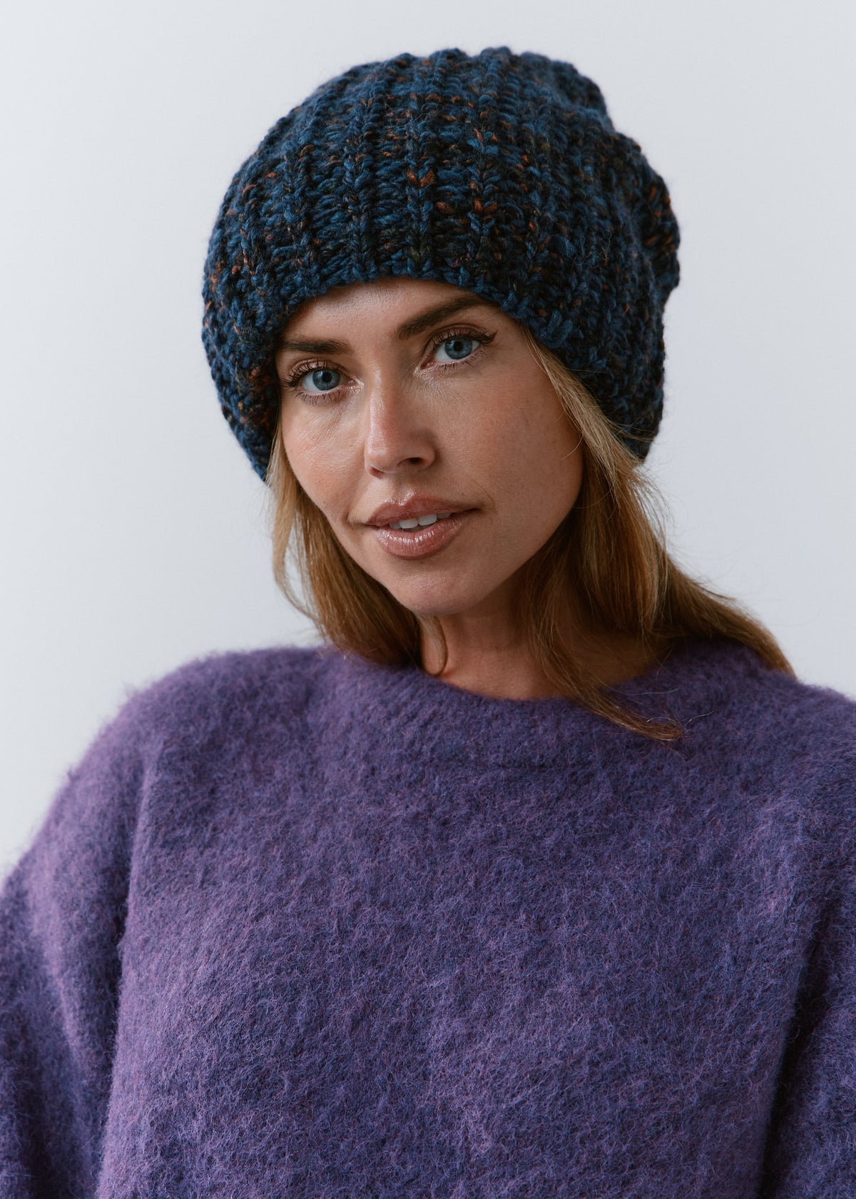 BRIKOLY Dark Lavender oversized knit beanie worn by a model in a front view over a purple sweater.