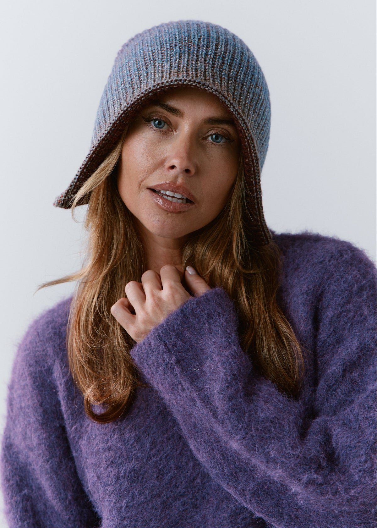 BRIKOLY Lisse Violet reversible ribbed knit beanie worn by a model in a front view over a purple sweater.