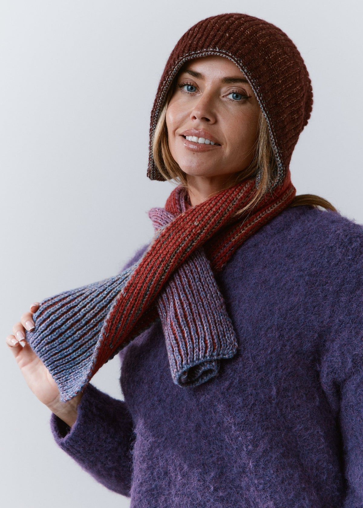 BRIKOLY Lisse Violet reversible ribbed knit beanie worn on its burgundy side with a matching scarf.