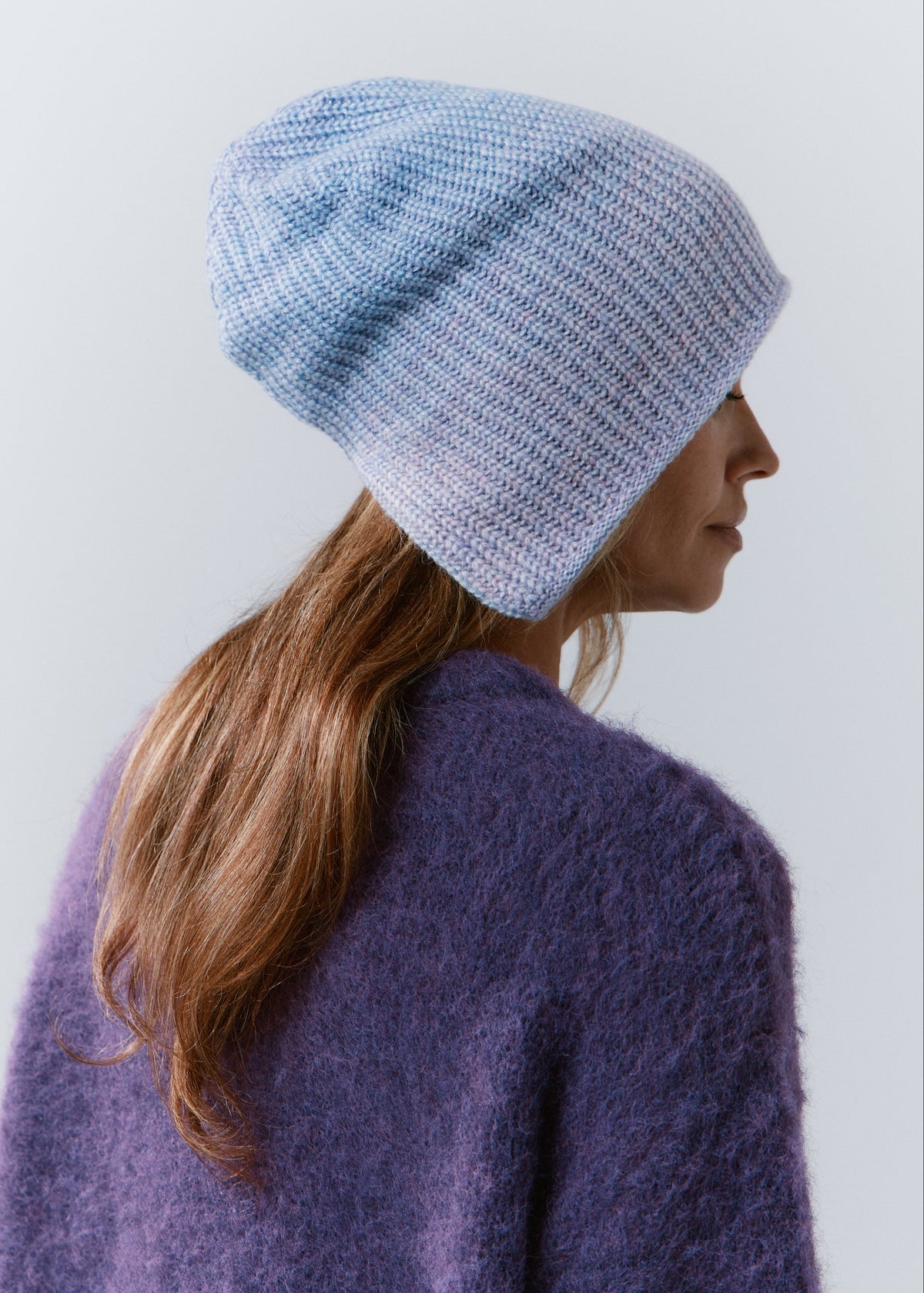 BRIKOLY Lisse Pink reversible knit beanie in pale blue and lilac tones, shown in profile to reveal its relaxed shape.