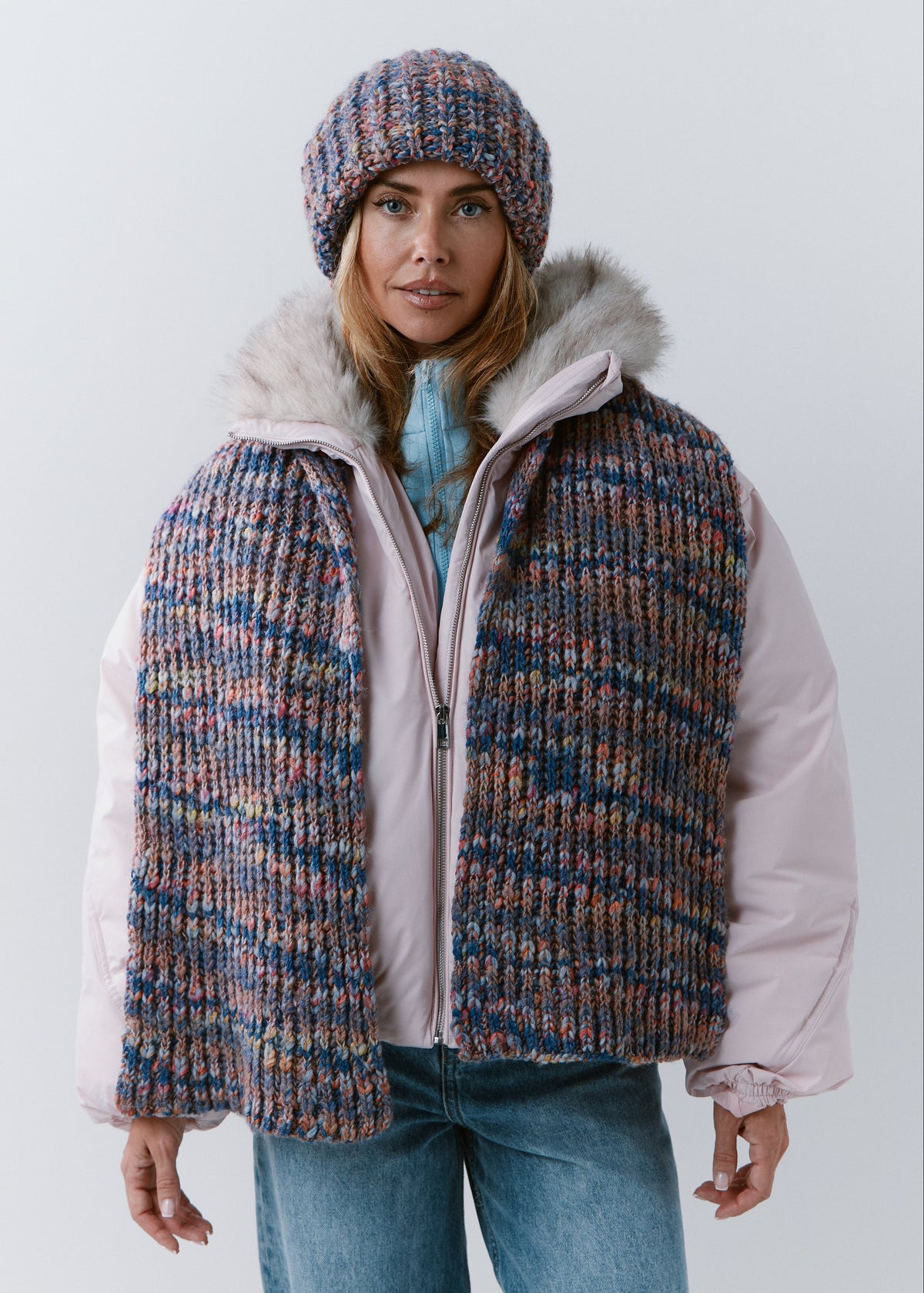 Front view of the BRIKOLY Pink Blue ribbed scarf draped over an open jacket with both ends hanging down.