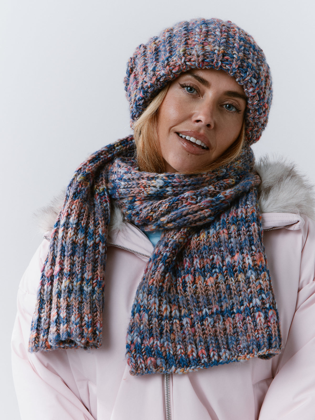 Model wearing the BRIKOLY Pink Blue ribbed knit scarf wrapped around her neck with both ends in front.
