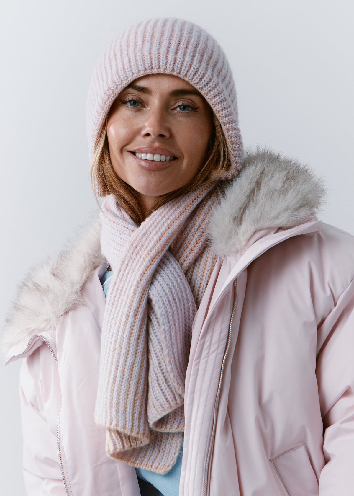 BRIKOLY Lisse Unicorn pale multicolor ribbed knit scarf secured around a smiling model's neck.