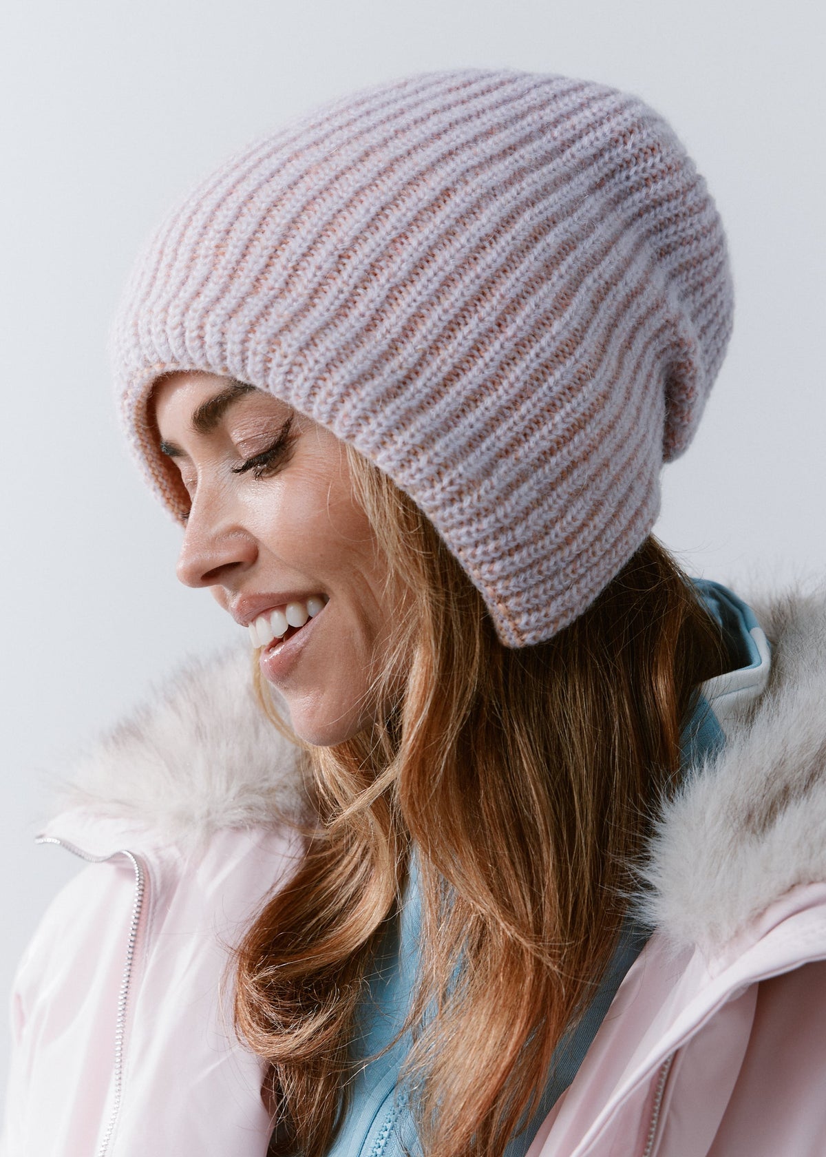 BRIKOLY Lisse Unicorn reversible ribbed knit beanie worn by a smiling model looking down in profile.