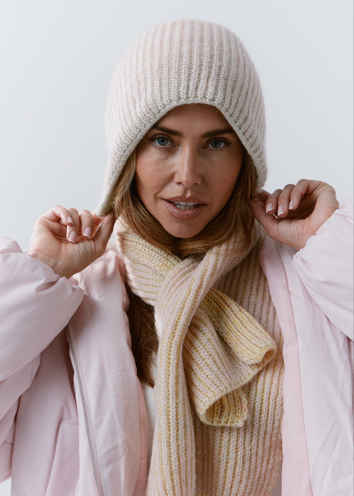 BRIKOLY Lisse Multi reversible ribbed knit beanie shown in a front view with a matching scarf and pink jacket.