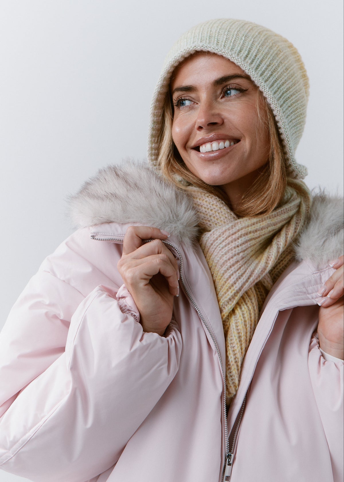 BRIKOLY Lisse Multicolor pale ribbed knit scarf shown on a smiling model holding a pink jacket collar.