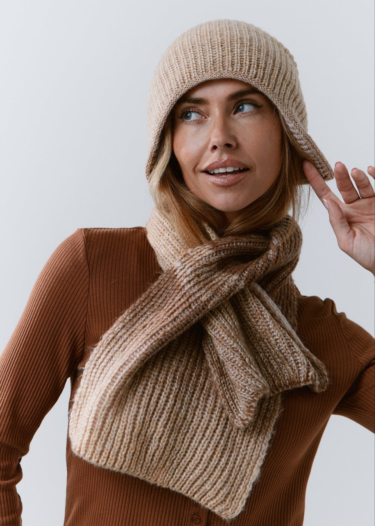 BRIKOLY Lisse Brown ribbed knit scarf shown on a model adjusting a matching beanie.
