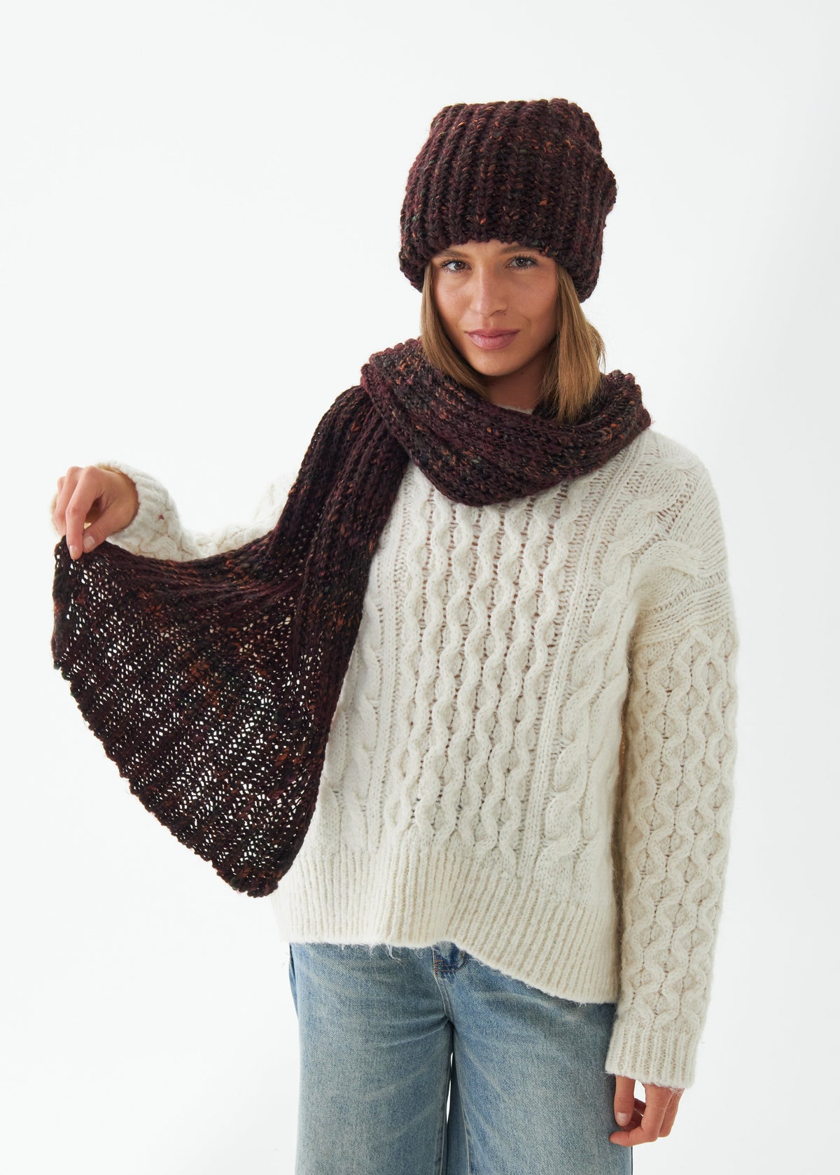 Oversized Maroon & Black alpaca-wool scarf: Three-quarter outfit view holding one end outward; beanie sold separately