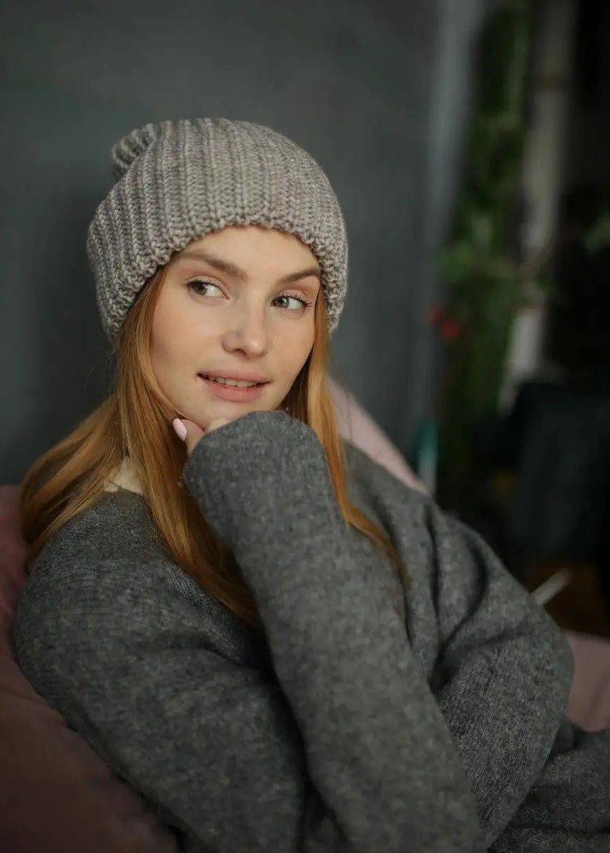 BRIKOLY London Gray & Beige knit beanie shown close up on a model holding her sweater collar.