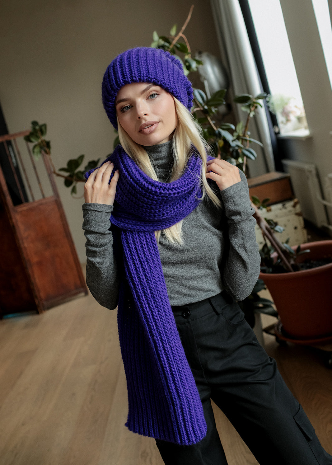 BRIKOLY London Lavender knit beanie worn by a model holding a matching scarf.