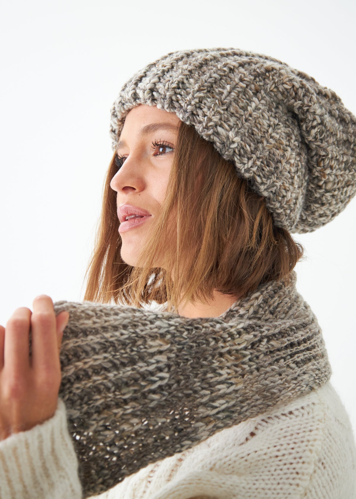 Oversized Gray alpaca-wool scarf: Close-up of scarf held near the neck; beanie sold separately