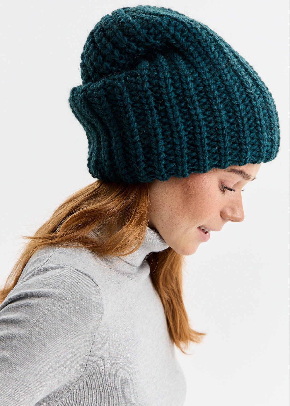 BRIKOLY London Emerald knit beanie shown in profile on a model looking down.