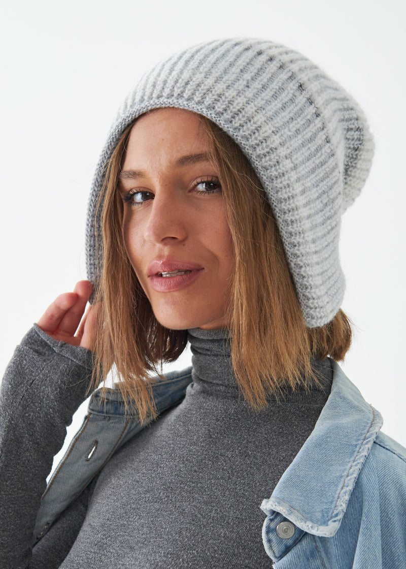 Woman wearing a gray knit beanie against a white background